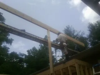 Carpenter setting a ridge beam over a new addition frame — Ice Dam Removal by Roofing Brothers in Gansevoort