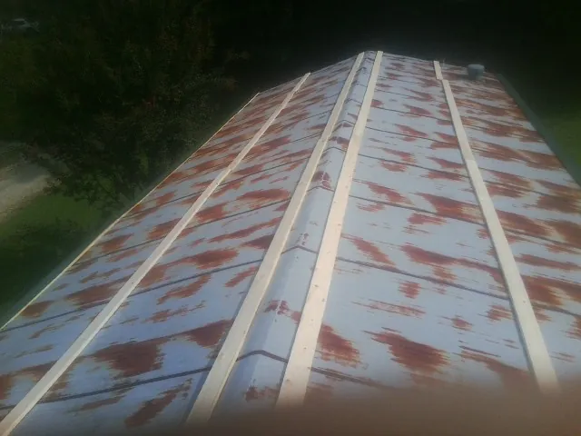 Rusted metal roof panels with new wood purlins before replacement — Storm Damage Roof Repair in Gansevoort by Roofing Brothers