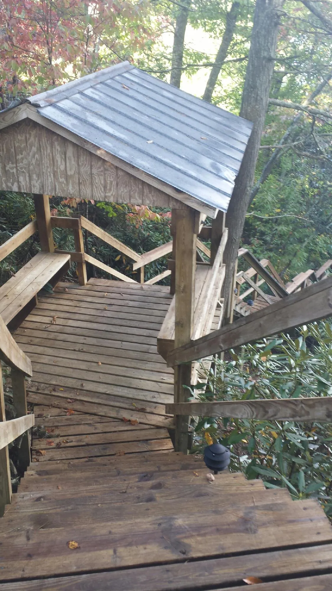 Metal roofed shelter over wooden steps on a wooded walkway — Skylight Repair & Installation work by our crew in Gansevoort