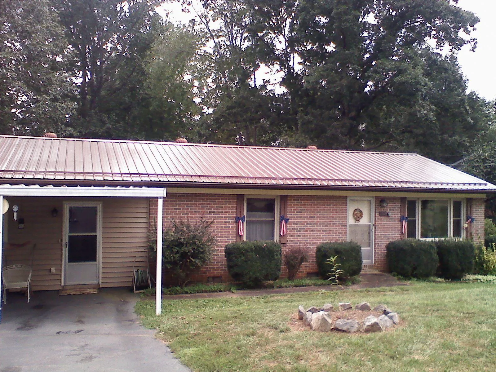 Bronze metal roof and carport on a brick ranch home — Roof Repair work by our crew in Gansevoort