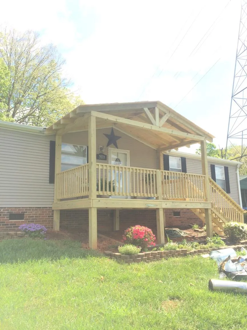 New gabled porch roof and deck railing added to a ranch home in Gansevoort